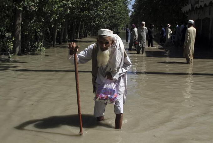 A displaced man wades through a flooded area after fleeing his flood-hit home, on the outskirts of Peshawar, Pakistan, Aug. 28, 2022. The flooding has all the hallmarks of a catastrophe juiced by climate change, but it is too early to formally assign blame to global warming, several scientists tell The Associated Press. Photo: AP 