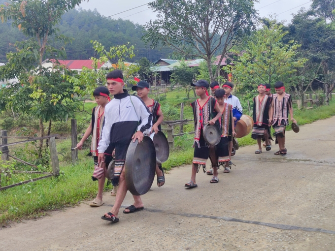 Các em học sinh trong trang phục truyền thống của đồng bào thiểu số mang theo chiêng trống đến trường.