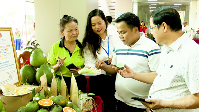 Các đại biểu tham quan các gian hàng trưng bày sản phẩm trái cây đạt chứng nhận OCOP của các huyện tại Hội nghị. Ảnh: Minh Sáng.
