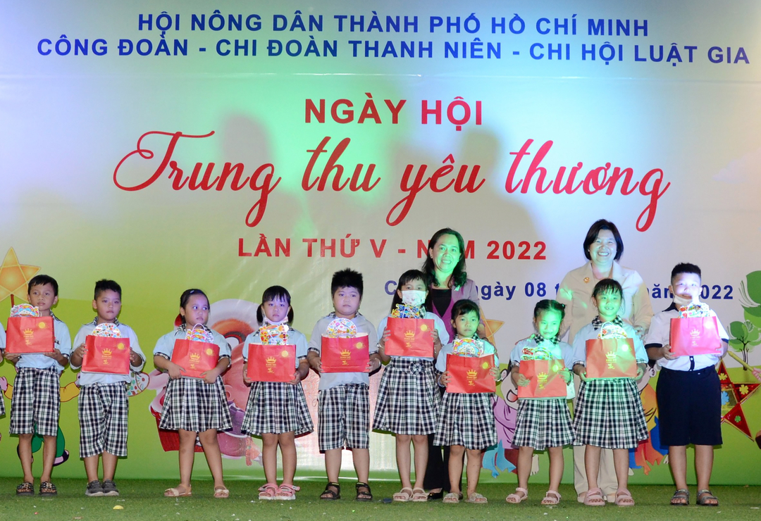 Bà Cao Xuân Thu Vân, Phó Chủ tịch Trung ương Hội Nông dân Việt Nam và bà Nguyễn Thanh Xuân, Chủ tịch Hội Nông dân TP.HCM trao quà trung thu cho các em thiếu nhi. Ảnh: T.Dương.