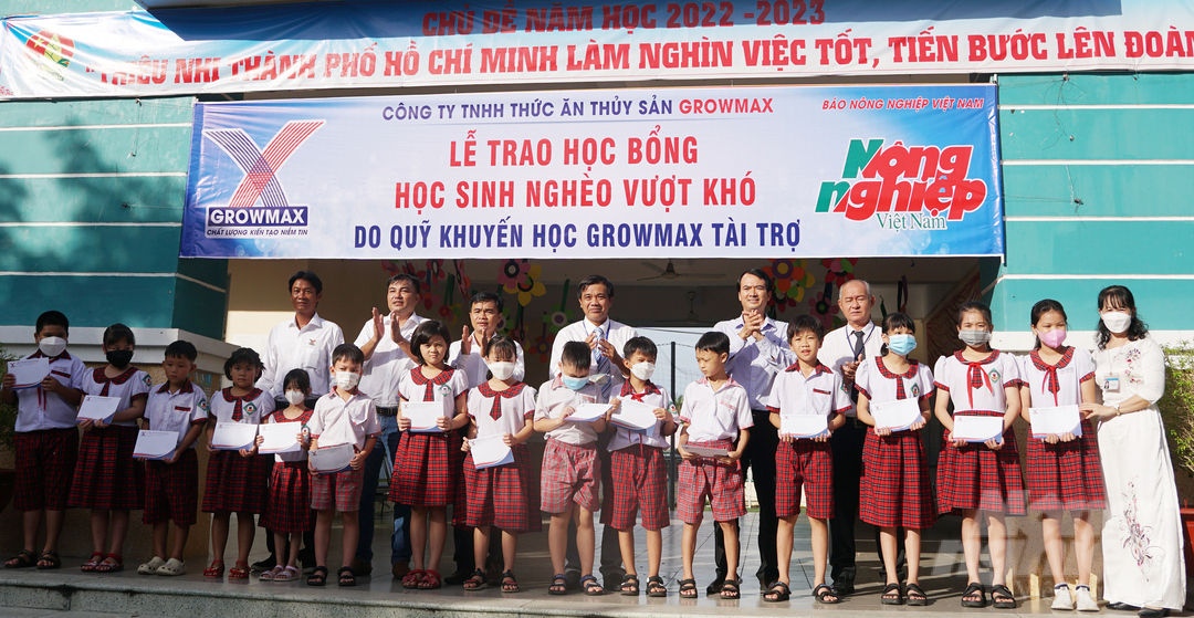 Đại diện Công ty TNHH thức ăn thủy sản GrowMax và Báo Nông nghiệp Việt Nam trao 15 suất học bổng cho các em học sinh Trường tiểu học Bình Khánh. Ảnh: Nguyễn Thủy.