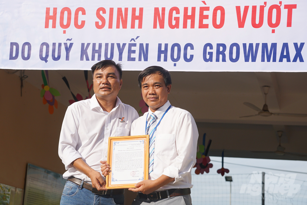 Thầy Đặng Thái Bình, Hiệu trưởng Trường tiểu học Bình Khánh trao Thư cảm ơn tới Công ty TNHH thức ăn thủy sản GrowMax. Ảnh: Nguyễn Thủy.