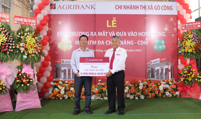 Ông Trần Phi Châu, Giám đốc Agribank Thị xã Cò Công (bên phải), trao bảng tượng trưng đóng góp cho quỹ an sinh xã hội của thị xã Gò Công. Ảnh: Quốc Trí.