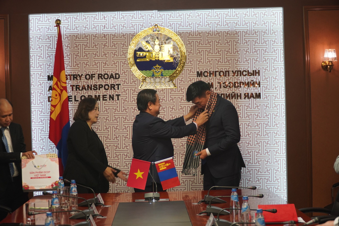 Bộ trưởng Lê Minh Hoan choàng khăn lưu niệm cho Bộ trưởng Bộ Đường bộ và Phát triển Giao thông Sandag Byambatsogt.