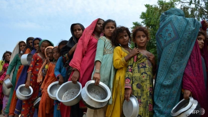 Displaced flood-affected people stand in a queue to receive food at a makeshift camp in flood-hit Sehwan, Pakistan. Photo: AFP