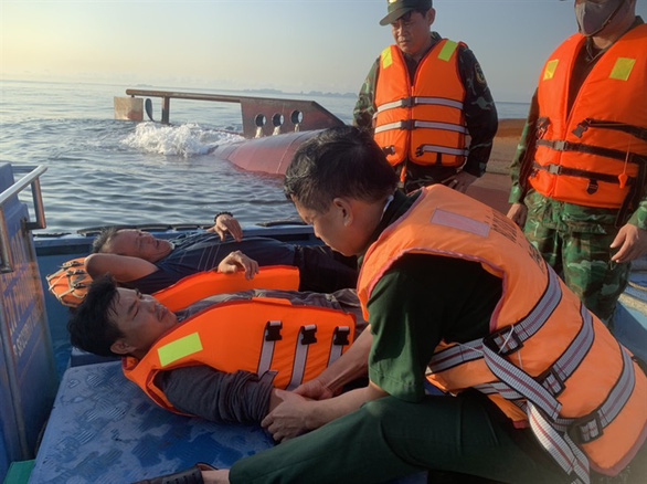 Lực lượng chức năng sơ cứu cho 2 nạn nhân bị rơi xuống biển sau khi tàu bị lật.
