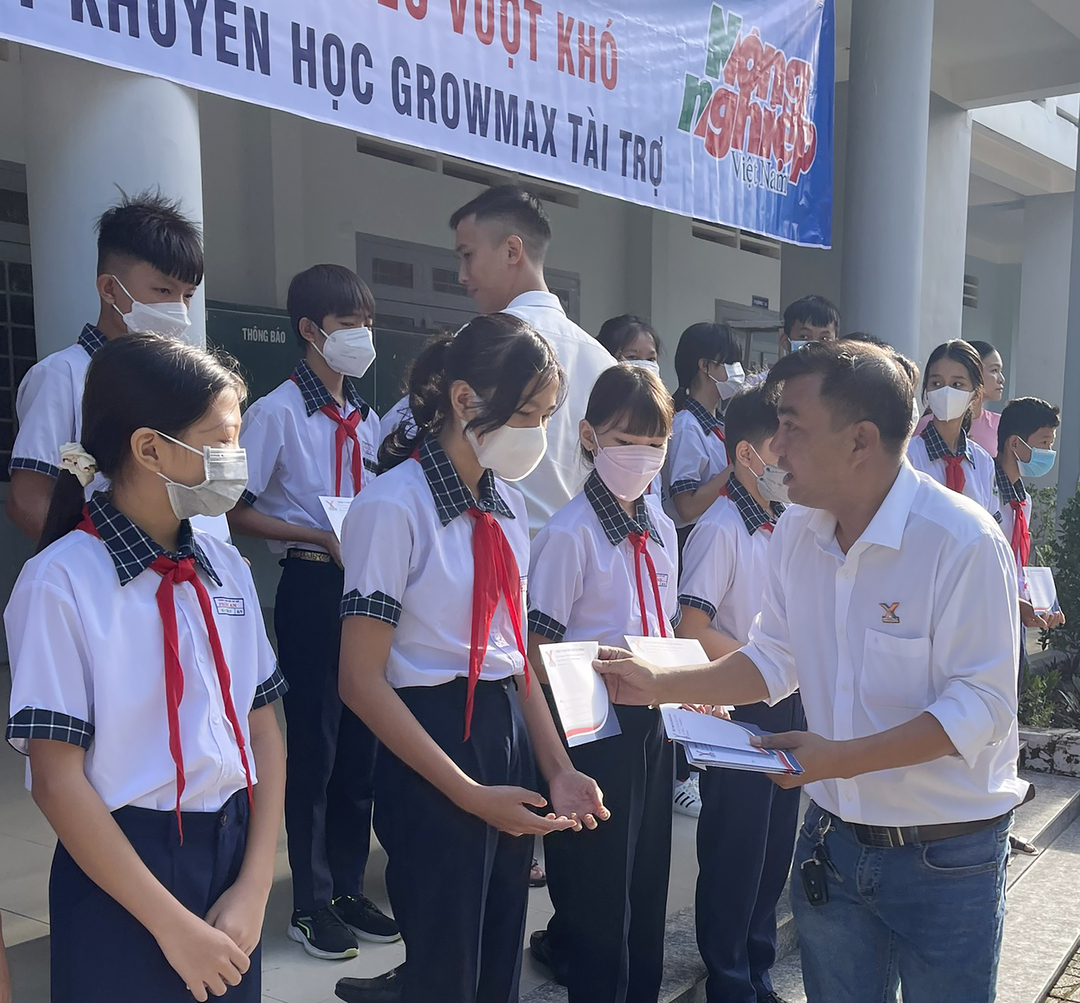 Ông Nguyễn Văn Dũng trao học bổng cho các em học sinh nghèo hiếu học. 