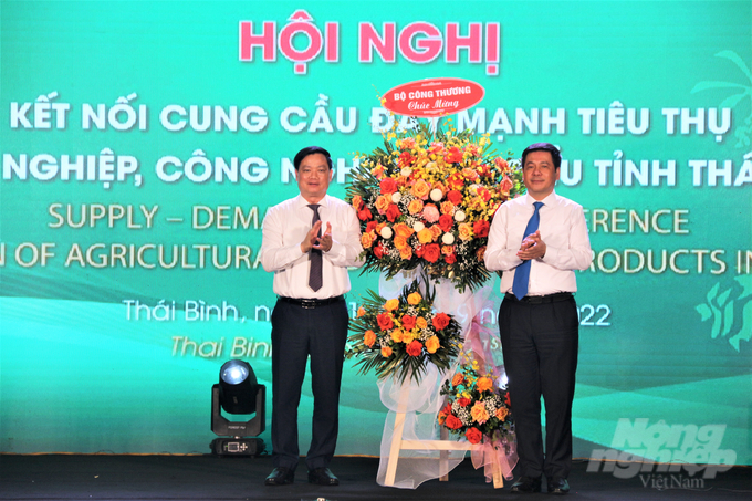 Bộ trưởng Bộ Công thương Nguyễn Hồng Diên (phải) tặng lẵng hoa chúc mừng Hội nghị. Ảnh: Phạm Hiếu.