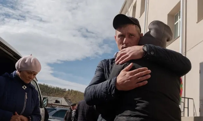 Những người được triệu tập tòng quân ở một ngôi làng tại khu vực Zakamensky, nước Cộng hòa Buryatia, ôm nhau trước khi lên đường. Ảnh: Guardian.