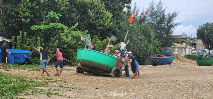 Ngư dân Bình Định di chuyển thuyền thúng lên bờ tránh bão Noru. Ảnh: Đ.T.