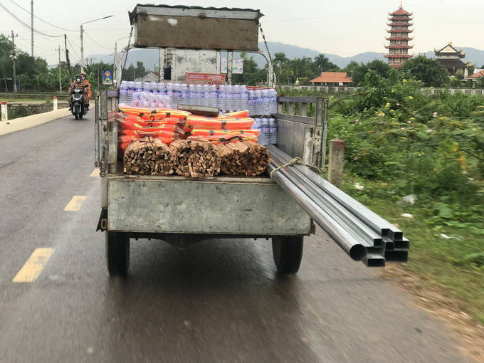 Áo phao, mì tôm và nước uống từ UBND xã Phước Thuận vận chuyển về xóm 3 thôn Diêm Vân để cung cấp cho bà con ứng phó với bão Noru. Ảnh: Vũ Đình Thung.