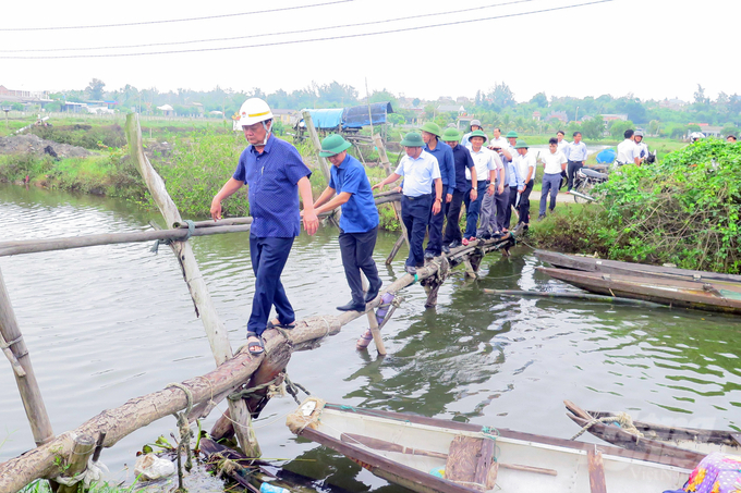 Bộ trưởng Lê Minh Hoan đi kiểm tra tại khu vực nuôi trồng thuỷ sản xã Quảng Công. Ảnh: CĐ.