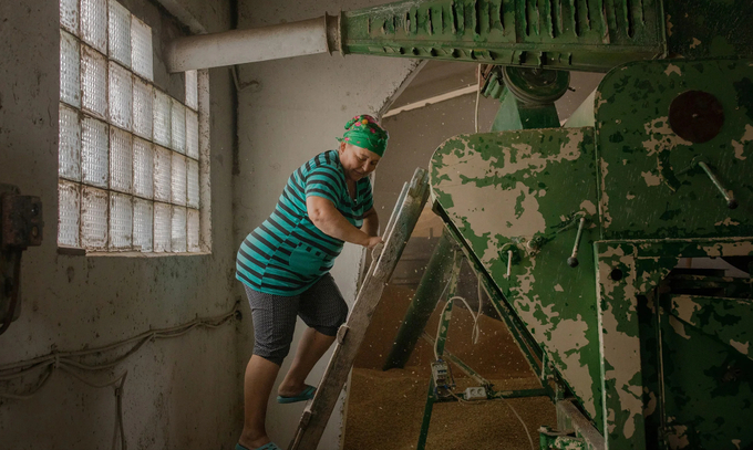 One of Nadia’s employees works at a machine which cleans and separates grain in Mykolaiv on July 19.