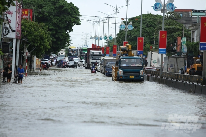 Nhiều phương tiện di chuyển chậm để hạn chế sóng nước ảnh hưởng đến người đi xe đạp và nhà dân bên đường.