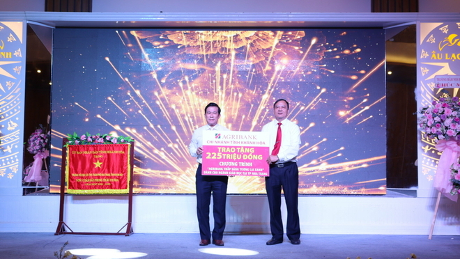 Ông Nguyễn Thanh Bình Phó Giám đốc Agribank Khánh Hoà (bên phải) trao tượng trưng số tiền 225 triệu đồng cho lãnh đạo Phòng Giáo dục và Đào tạo TP. Nha Trang.