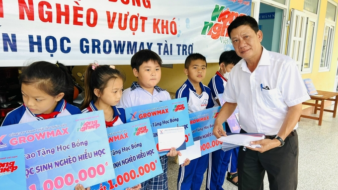 Anh Dương Văn Huy, Giám đốc khu vực Bạc Liêu II (Công ty TNHH Thức ăn thủy sản GrowMax) trao học bổng cho học sinh. Ảnh: Trọng Linh.
