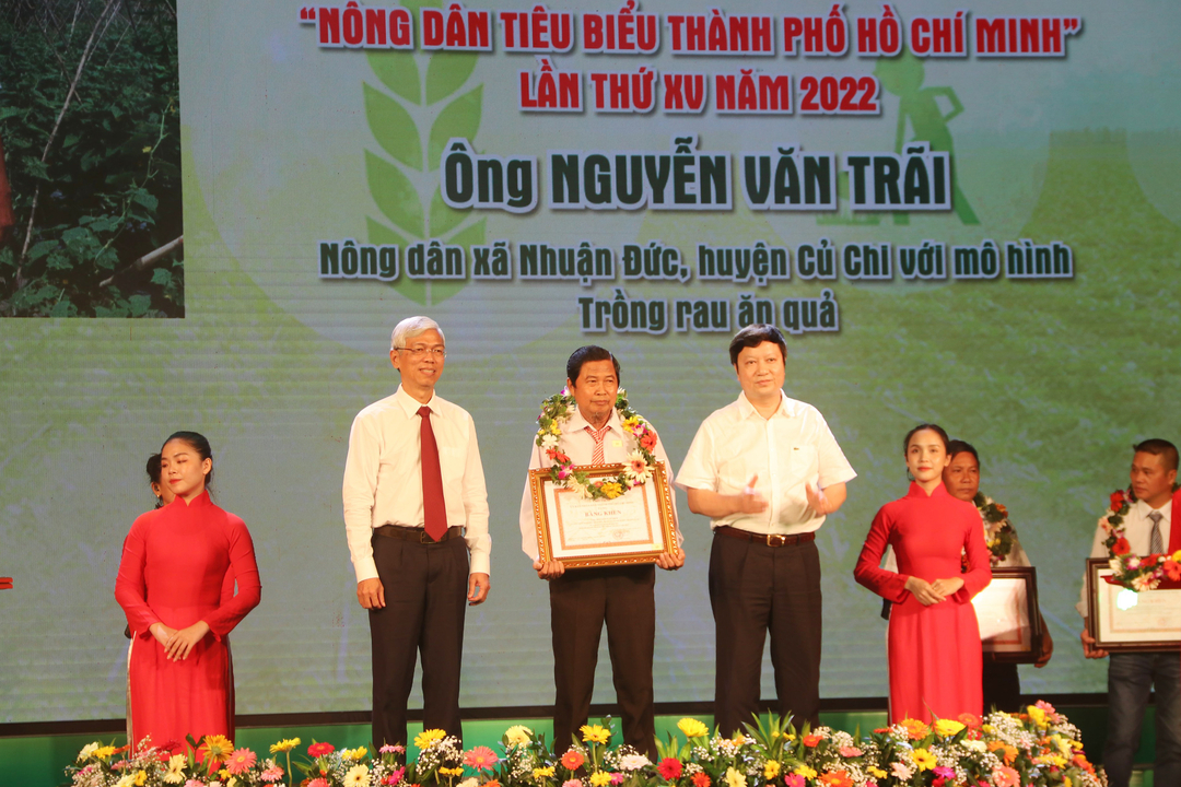 Ông Võ Văn Hoan, Phó Chủ tịch UBND TP.HCM và ông Nguyễn Văn Đại, Hiệu trưởng Trường Trung Cấp Nông dân Việt Nam trao tặng bằng khen cho ông Nguyễn Văn Trãi với mô hình trồng rau ăn quả. Ảnh: Nguyễn Thủy.