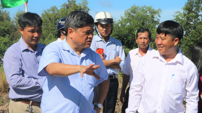 Deputy Minister of Agriculture and Rural Development Tran Thanh Nam (2nd from left) talks with the Director of Phu Hoa Cooperative Nguyen Van Huynh (first right ) about building and developing a new model of cooperative.