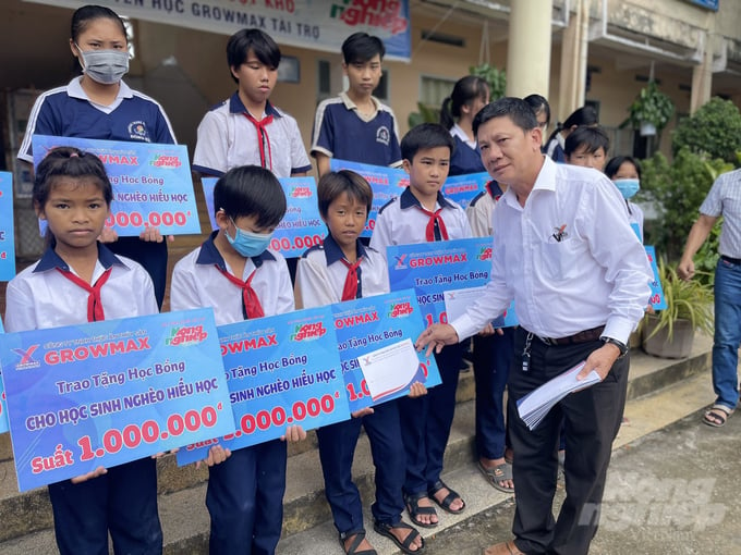 Anh Dương Văn Huy, Giám đốc khu vực Bạc Liêu II (Công ty Thức ăn Thủy sản GrowMax) trao học bổng cho các em học sinh tại Trường Trung học cơ sở Đông Hải. Ảnh: Trọng Linh.