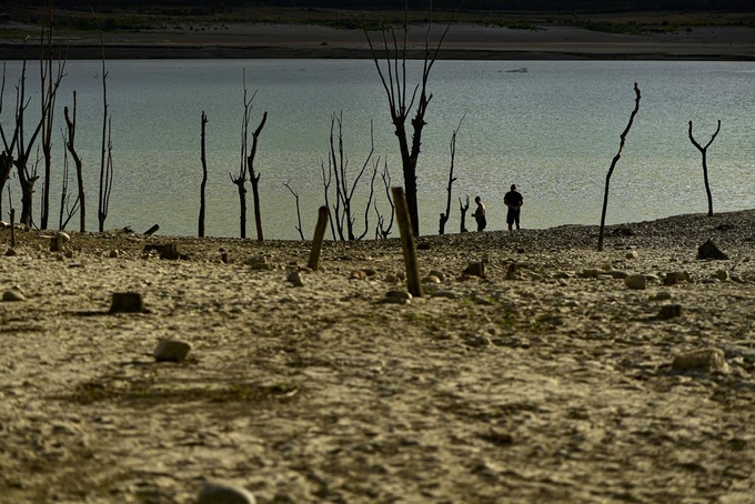 People walk close to the border at Yesa's reservoir affected by drought, on a sunny summer day in Yesa, around 55 kilometers (34,17 miles), from Pamplona, northern Spain, Sept. 14, 2022. Widespread drought that dried up large parts of Europe, the United States and China this past summer was made 20 times more likely by climate change, according to a new study.  Photo: AP
