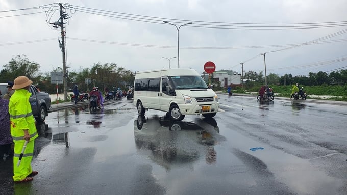 Lực lượng Cảnh sát giao thông phân luồng trên Quốc lộ 1A, hướng dẫn phương tiện giao thông tránh khu vực bị ngập nước. Ảnh: L.K. 