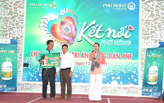 Ông Nguyễn Đình Nhân, Trưởng phòng Quảng bá Công ty TNHH Phú Nông trao giải cho nông dân trúng thưởng 1 điện thoại Samsung Galaxy A03. Ảnh: Ngọc Hân.