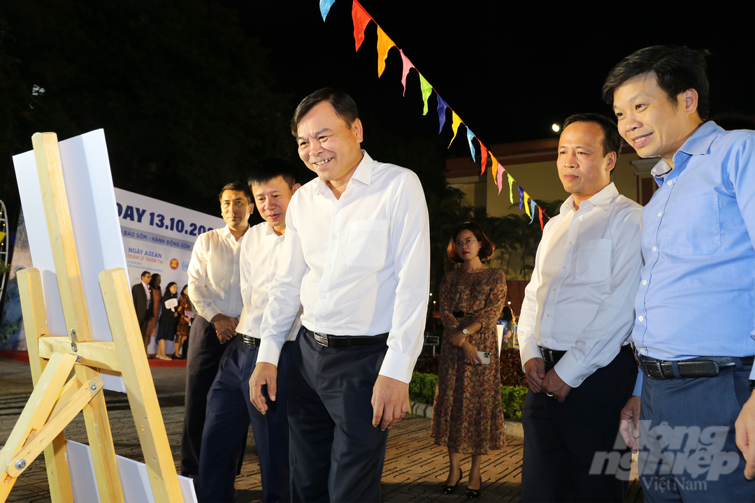 Thứ trưởng Bộ NN-PTNT Nguyễn Hoàng Hiệp cùng các đại biểu xem triển lãm ảnh 'Phụ nữ trước bão giông'. Ảnh: Diệu Vy.