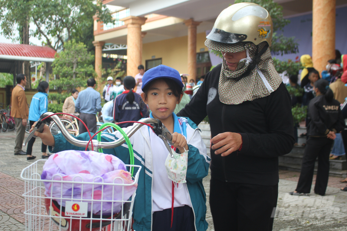 Mẹ con em Nguyễn Ngọc Bảo Hân vui mừng khi có chiếc xe đạp mới để rút ngắn quảng đường đến trường. Ảnh: Công Điền.