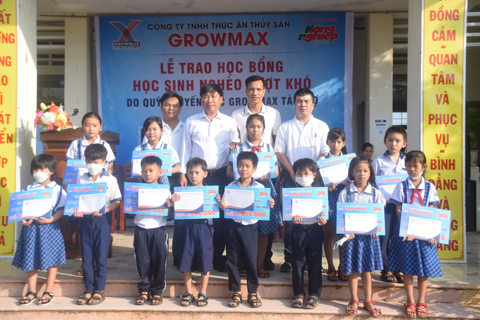 Cán bộ, nhân viên Công ty TNHH thức ăn thủy sản GrowMax -Miền Trung 2 trao học bổng cho 15 học sinh Trường Tiểu học số 2 Tam Quan Nam (Thị xã Nhoài Nhơn, Bình Định). Ảnh: V.Đ.T.