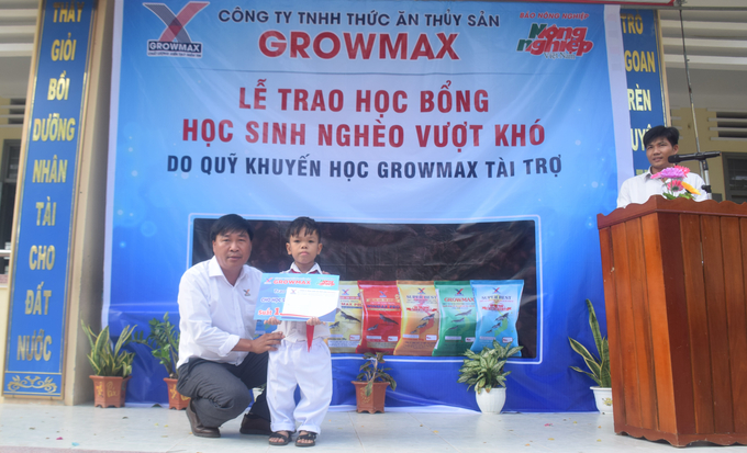 Ông Nguyễn Văn Đại, Giám đốc Miền Trung 2- Công ty TNHH thức ăn thủy sản GrowMax cùng em học sinh khuyết tật của Trường Tiểu học Mỹ Thành 2. Ảnh: V.Đ.T.