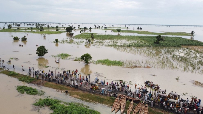 People walk through floodwaters with flooded farmlands forground after heavy rainfall in Hadeja, Nigeria, Sept 19, 2022. West and Central African countries are battling deadly floods that have upended lives and livelihoods, raising fears of further disruption of food supplies in many areas battling armed conflict. 'Above-average rainfall and devastating flooding' have affected 5 million people this year in 19 countries across West and Central Africa, according to a new U.N. World Food Program situation report. Photo: AP