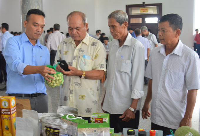Các đại biểu tham gia diễn đàn dùng điện thoại thông minh quét mã QR Code truy xuất nguồn gốc sản phẩm nông nghiệp của các đơn vị tại Hậu Giang sản xuất. Ảnh: Trung Chánh.