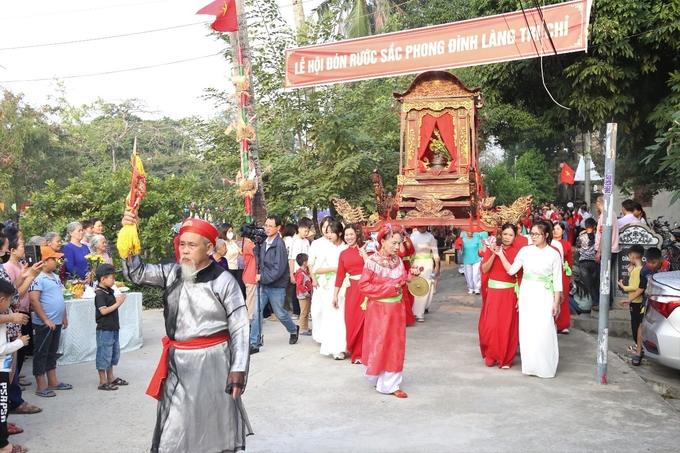 Làng Tri Chỉ mở hội tưng bừng trong ngày trao sắc phong, đây là một trong những lễ rước kiệu quy mô lớn nhất từ trước đến nay. Đoàn rước đi qua nhiều địa điểm lịch sử trong làng thu hút sự tham gia, quan tâm của nhiều người dân trong khu vực. Ảnh: Lâm Hùng.