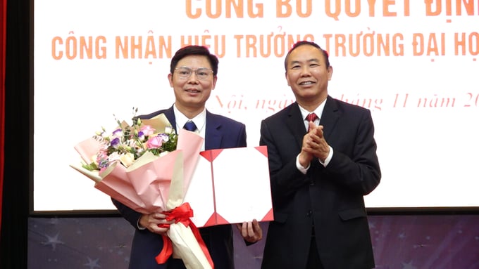 Thứ trưởng Phùng Đức Tiến (bên phải) trao quyết định điều động và bổ nhiệm Hiệu trưởng Trường Đại học Lâm nghiệp đối với GS.TS Phạm Văn Điển. Ảnh: Quang Linh.
