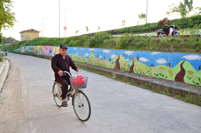 Những con đường ven đê Đáy được tô điểm bằng hoa và tranh bích họa. Ảnh: Dương Đình Tường. 