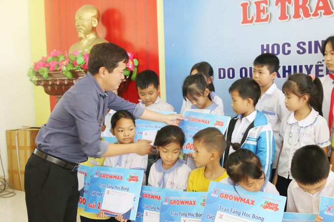 Ông Đặng Văn Thành, Giám đốc Công ty GrowMax khu vực Miền Bắc trao học bổng cho các em học sinh. Ảnh: Đinh Mười.