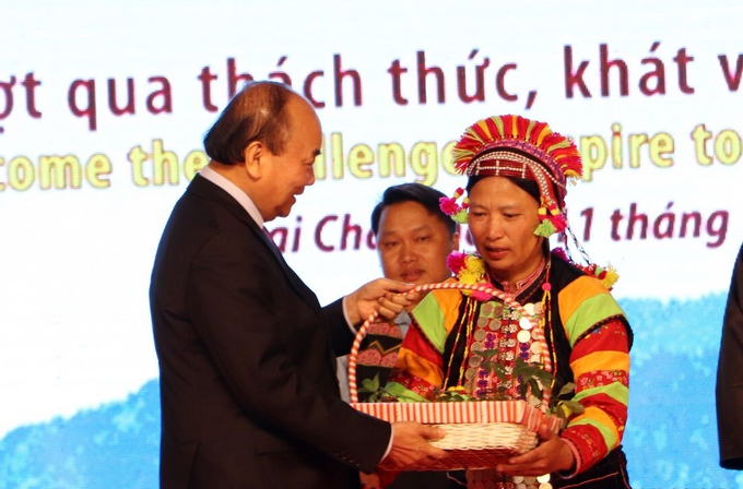 Chủ tịch nước Nguyễn Xuân Phúc tặng cây giống sâm Lai Châu cho hộ gia đình đồng bào dân tộc thiểu số ở Lai Châu. Ảnh: T.L.