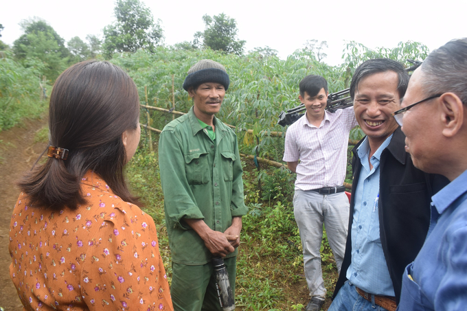 Nông dân Đinh Văn Trác (đứng giữa), người dân tộc Bana ở xã An Toàn đang tham gia trồng cây dược liệu trò chuyện cùng đoàn công tác.