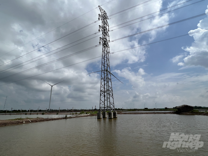 Trụ móng VT4 và đường dây 110KV của dự án điện gió số 2 trên đất nuôi trồng thủy sản của gia đình chị Xinh. Ảnh: Trọng Linh.