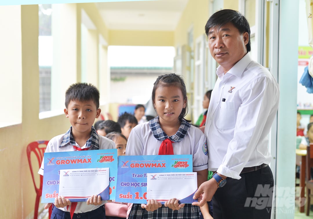 Ông Nguyễn Văn Đại, Giám đốc Khu vực miền Trung 2 (Công ty TNHH Thức ăn Thủy sản GrowMax) trao phần quà cho các học sinh Trường tiểu học Sơn Hải. Ảnh: Minh Hậu.