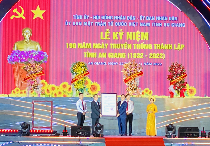 Thay mặt lãnh đạo Đảng, Nhà nước, Ủy viên Bộ Chính trị, Trưởng ban Kinh tế Trung ương Trần Tuấn Anh trao Quyết định của Thủ tướng Chính phủ công nhận ngày 22 tháng 11 hàng năm là 'Ngày truyền thống tỉnh An Giang' cho Bí thư Tỉnh ủy An Giang Lê Hồng Quang. Ảnh: Lê Hoàng Vũ.