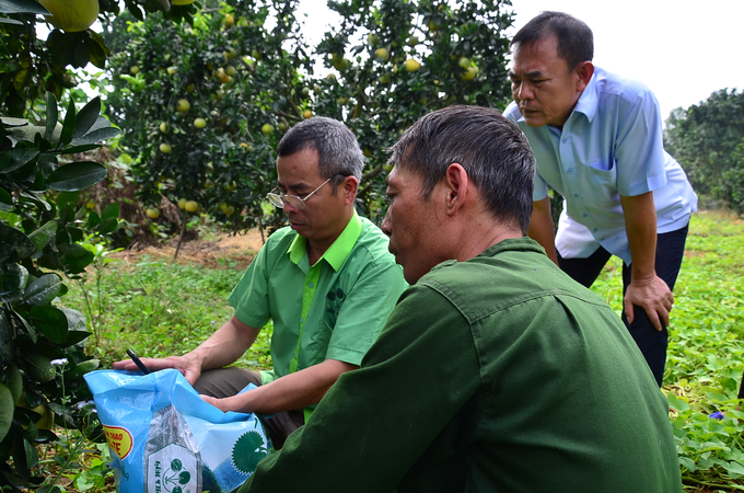 Anh Nguyễn Đình Quang-nhân viên kinh doanh của Công ty CP Supe Phốt phát và Hóa chất Lâm Thao đang mở bao để kiểm tra khuyến mãi vàng cho một nông dân. Ảnh: Dương Đình Tường.