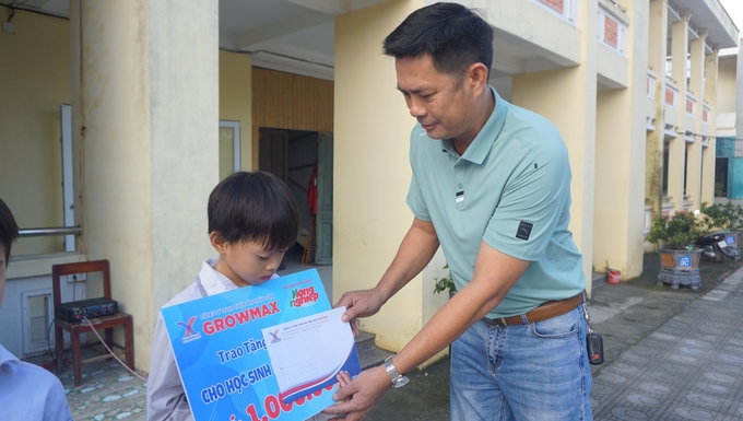 Ông Dương Văn Trường, đại diện nhà phân phối thức ăn thuỷ sản GrowMax tại Thị xã Nghi Sơn trao quà cho học sinh nghèo tại Trường tiểu học Hải Thanh A.