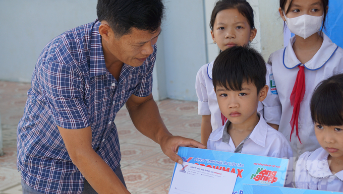 Cá nhân ông Trần Văn Long, đại diện đơn vị phân phối sản phẩm thức ăn thủy sản GrowMax trao riêng 10 suất quà cho các em học sinh Trường tiểu học Hoằng Trường. Ảnh: Quốc Toản.