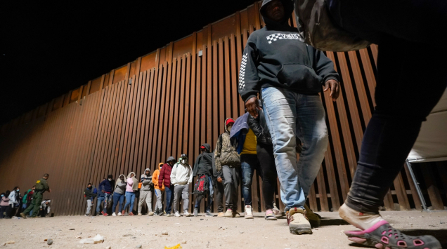 A group of migrants, mostly from Cuba, line up to board a bus after crossing the border from Mexico and surrendering to authorities to apply for asylum on Thursday, Nov. 3, 2022, near Yuma, Arizona. Photo: AP 