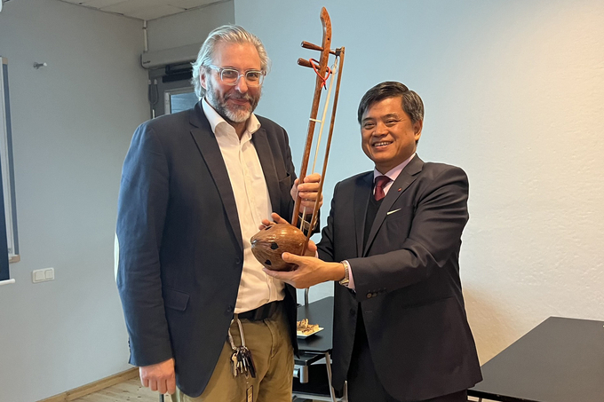 Deputy Minister Tran Thanh Nam gifting Principal Claus-Christian Eckhardt a musical instrument made from fruit and coconut wood.