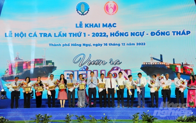 Thứ Trưởng Bộ NN-PTNT Phùng Đức Tiến cùng UBND tỉnh Đồng Tháp tặng kỷ niệm chương tôn vinh người nuôi và doanh nghiệp chế biến cá tra. Ảnh: Lê Hoàng Vũ.