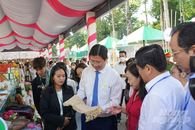 Ông Huỳnh Minh Tuấn, Phó Chủ tịch UBND tỉnh Đồng Tháp và ông Lê Văn Sử, Phó Chủ tịch UBND tỉnh Cà Mau đến tham quan sản phẩm lụa tơ sen của Đồng Tháp. Ảnh: Lê Hoàng Vũ.