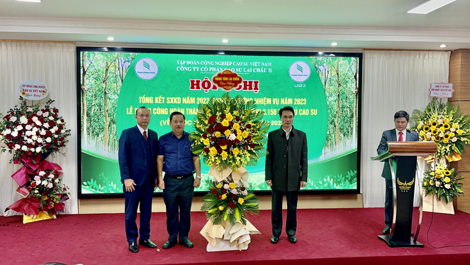 Ông Hà Trọng Hải, Phó Chủ tịch UBND tỉnh Lai Châu (phải) tặng hoa chúc mừng Công ty Cổ phần Cao su Lai Châu 2 vượt kế hoạch sản xuất năm 2022. Ảnh: H.Đ.