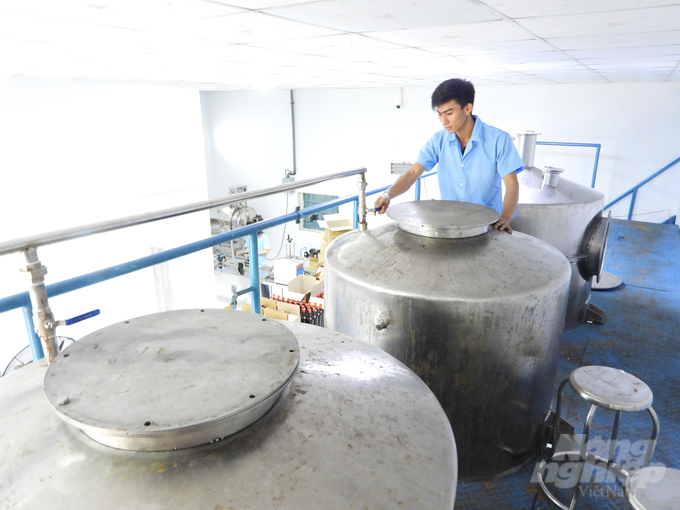 Nhân viên Công ty TNHH Vương Ngọc kiểm tra các thùng ủ nước mắm điều. Ảnh: Trần Trung.